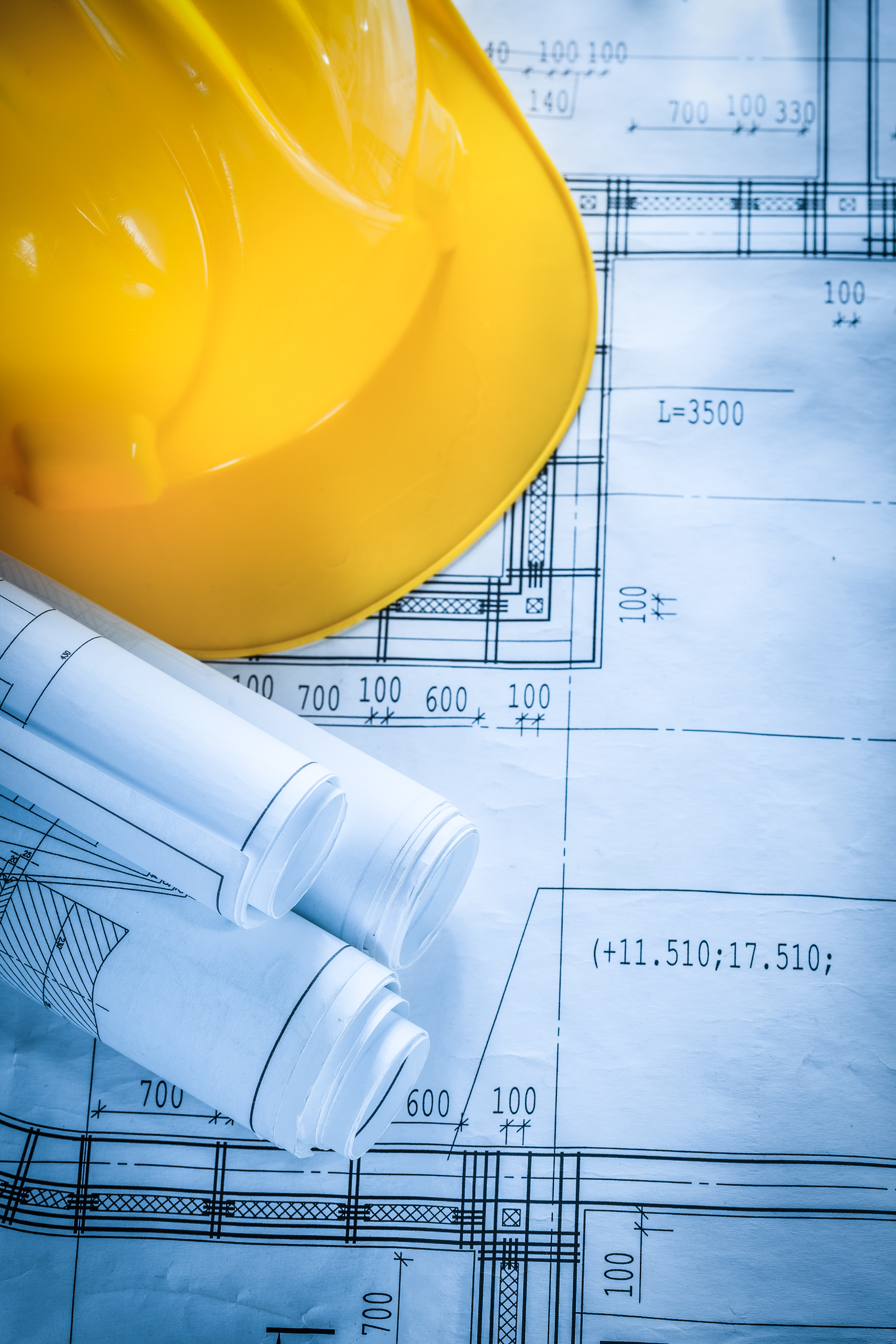 Safety hard hat construction drawings on blueprint.